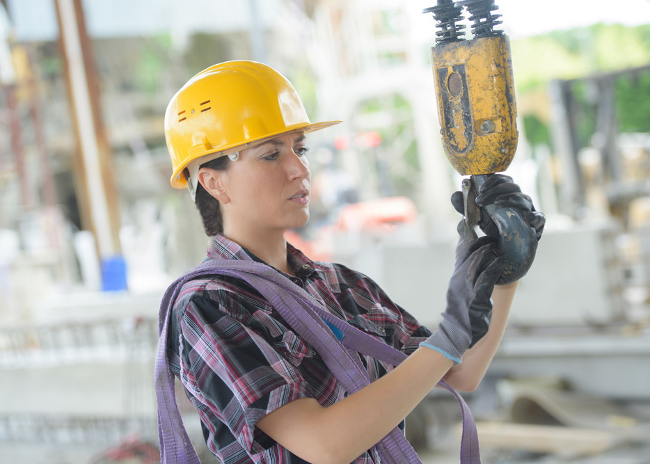 Woman working on construction equipment